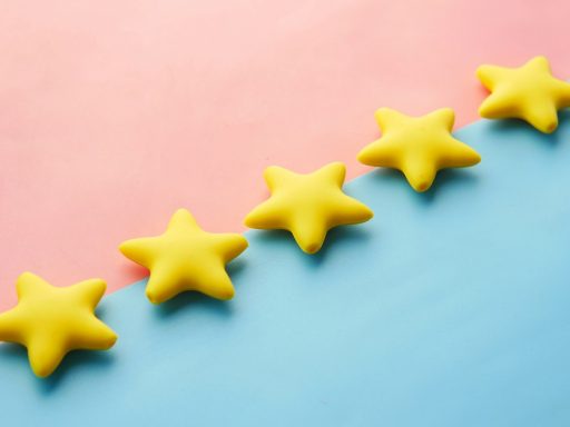 a row of yellow stars sitting on top of a blue and pink surface