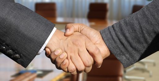 Twee ondernemers schudden elkaar de hand bij de overdracht van een bedrijf