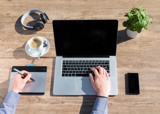 Freelancer werkt geconcentreerd vanuit een thuiskantoor met laptop en notitieblok