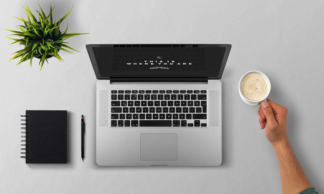 Persoon die een opvolgmail schrijft op een laptop aan een bureau