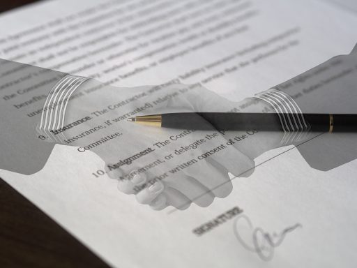 Twee zakenmensen schudden handen bij het ondertekenen van een overnamecontract
