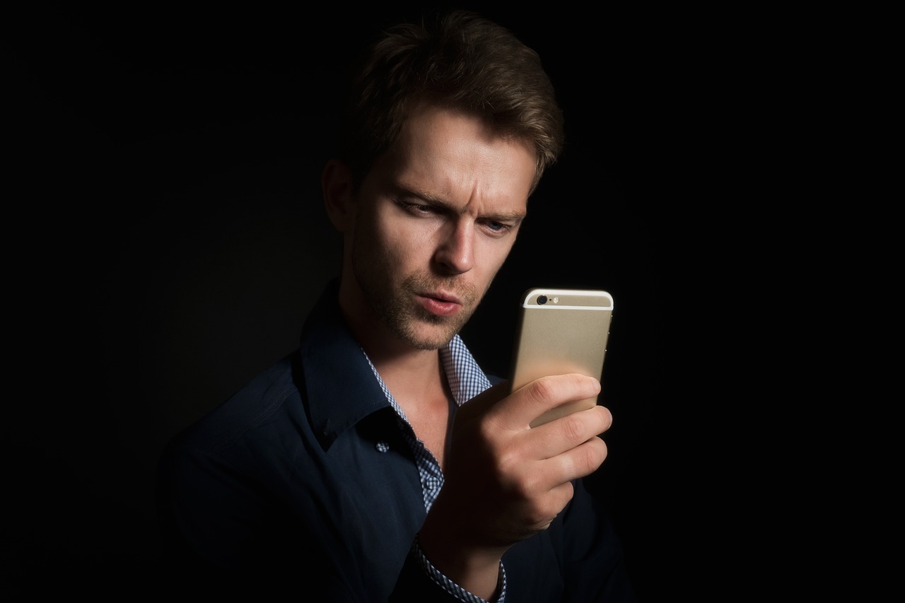 Persoon die een beleggingsapp bekijkt op zijn telefoon om een broker te kiezen voor een kleine maandelijkse inleg
