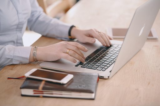 Een vrouw schrijft notities in een notitieboek terwijl ze haar loopbaan in het Engels voorbereidt