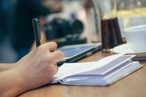 Persoon die vaardigheden en taken opschrijft op papier als onderdeel van een competentie-mapping oefening