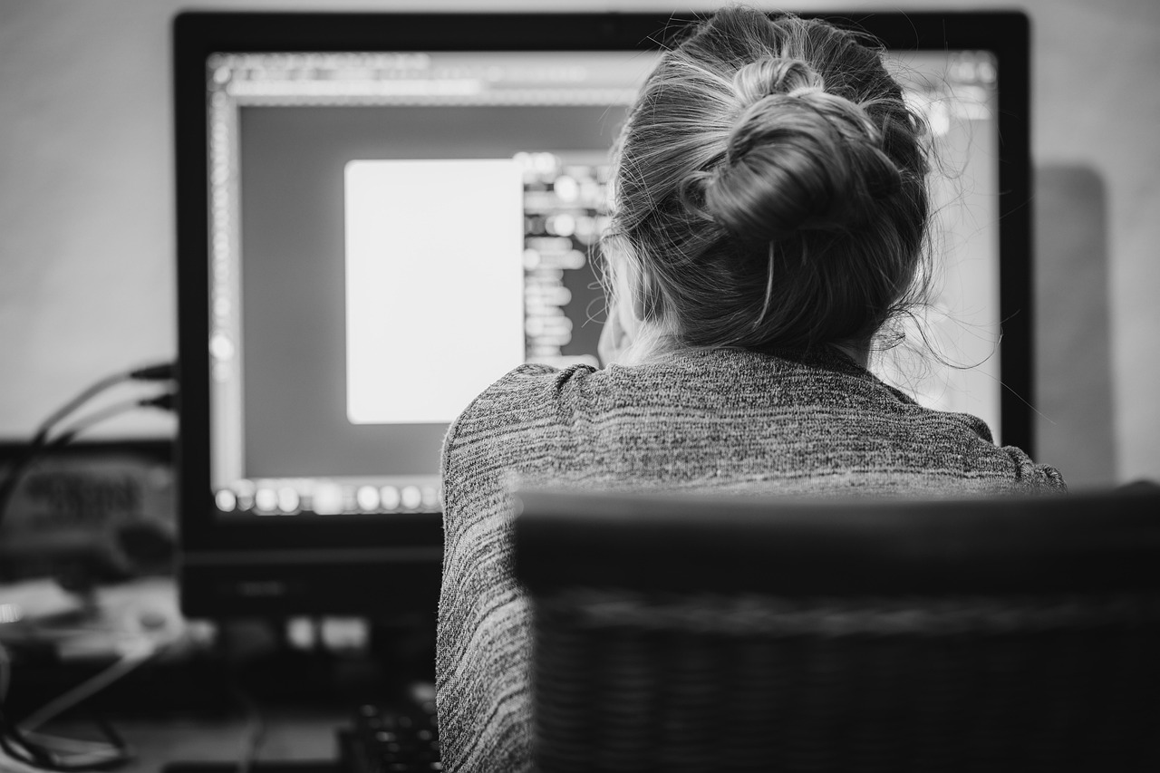 ICT-freelancer bekijkt een contract op zijn laptop aan een bureautafel