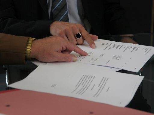Freelancer die een contract doorleest en ondertekent aan een bureau